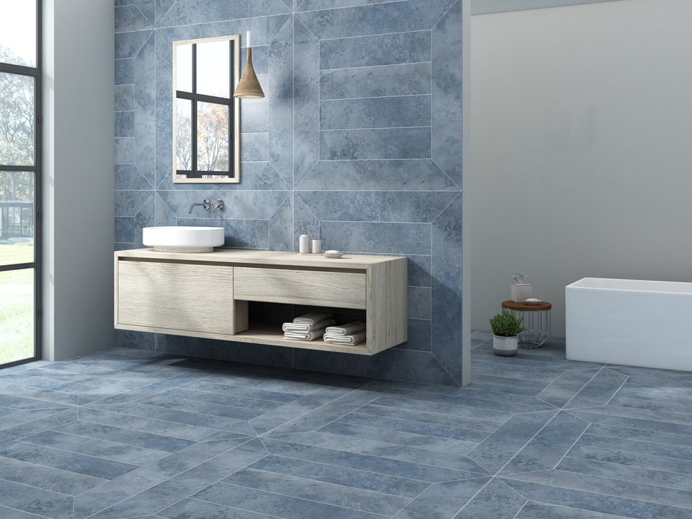 Savremeno kupatilo sa plavim keramičkim pločicama na podu i zidu, visećim drvenim ormarićem i minimalističkim lavaboom